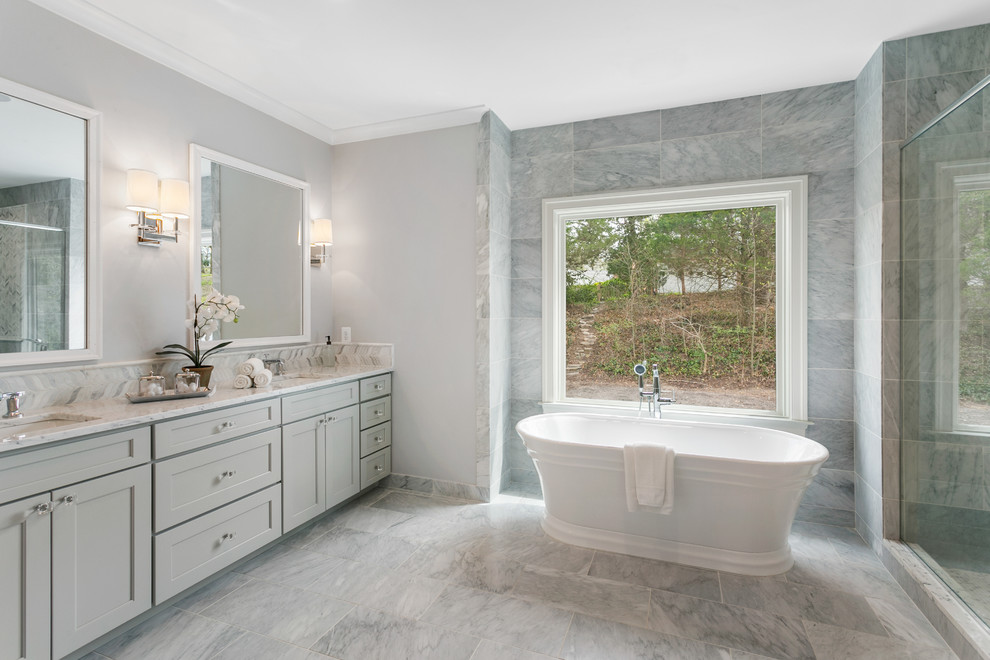 Design ideas for a mid-sized contemporary master bathroom in Other with shaker cabinets, grey cabinets, a freestanding tub, a one-piece toilet, gray tile, grey walls, an undermount sink, grey floor, a hinged shower door, multi-coloured benchtops and a corner shower.