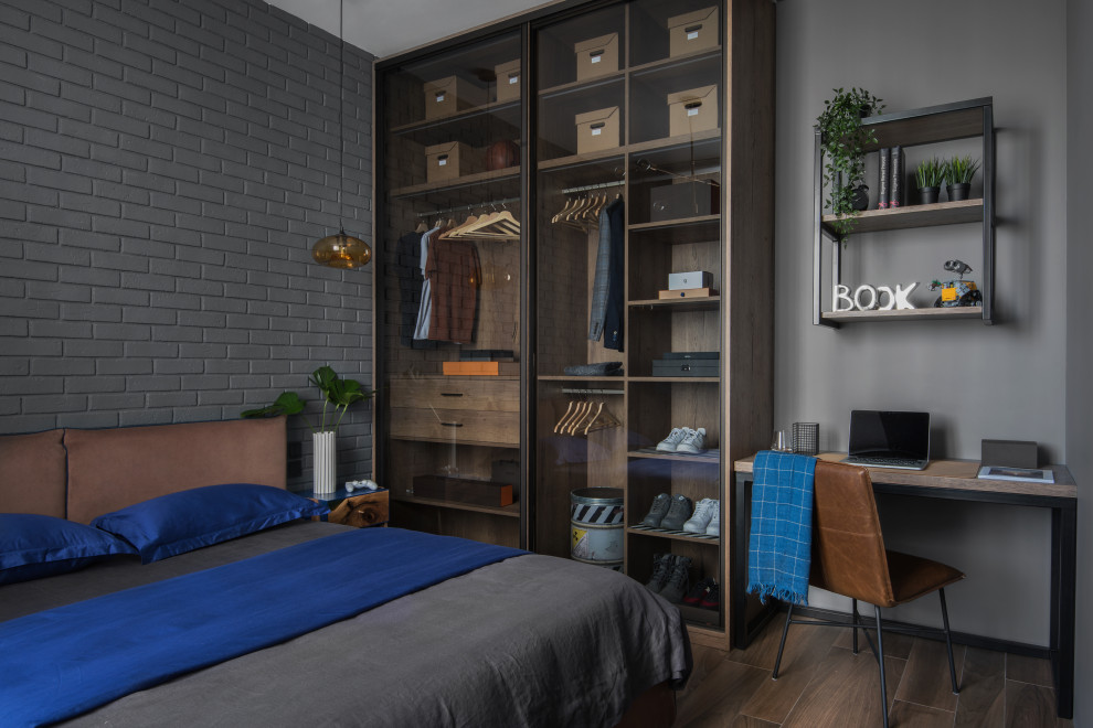 Imagen de dormitorio principal industrial pequeño con paredes grises, suelo de baldosas de porcelana, suelo marrón y ladrillo