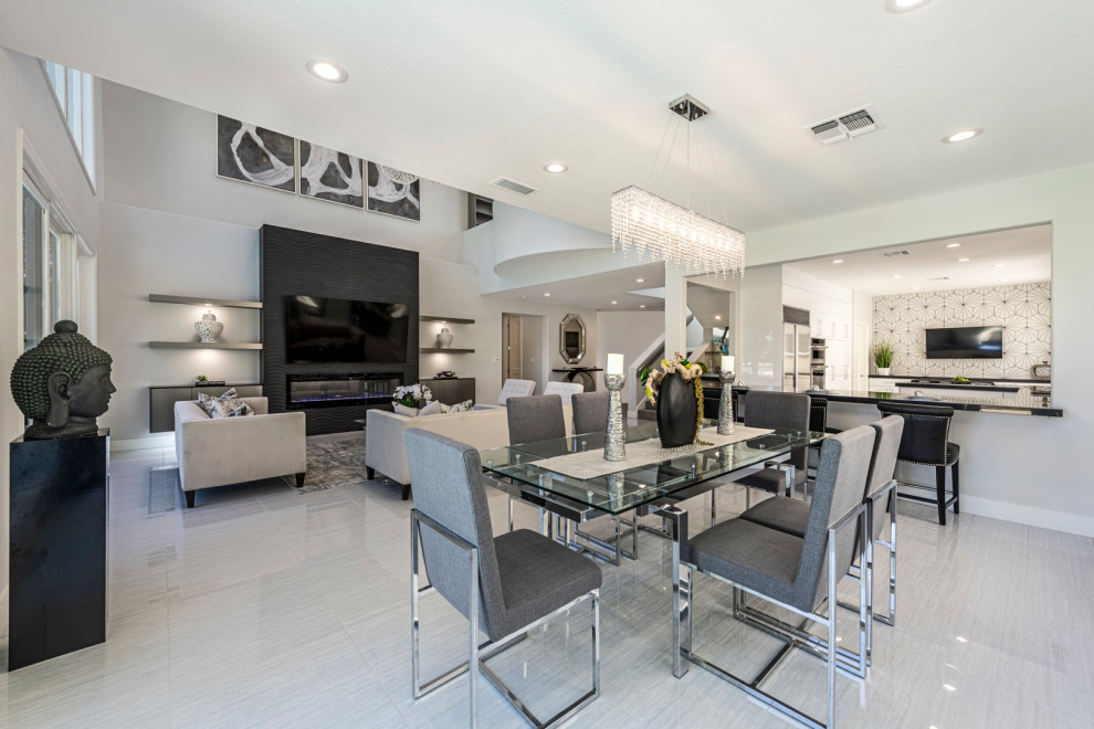 This is an example of a mid-sized modern kitchen/dining combo in Las Vegas with grey walls, ceramic floors, a standard fireplace, a tile fireplace surround and grey floor.