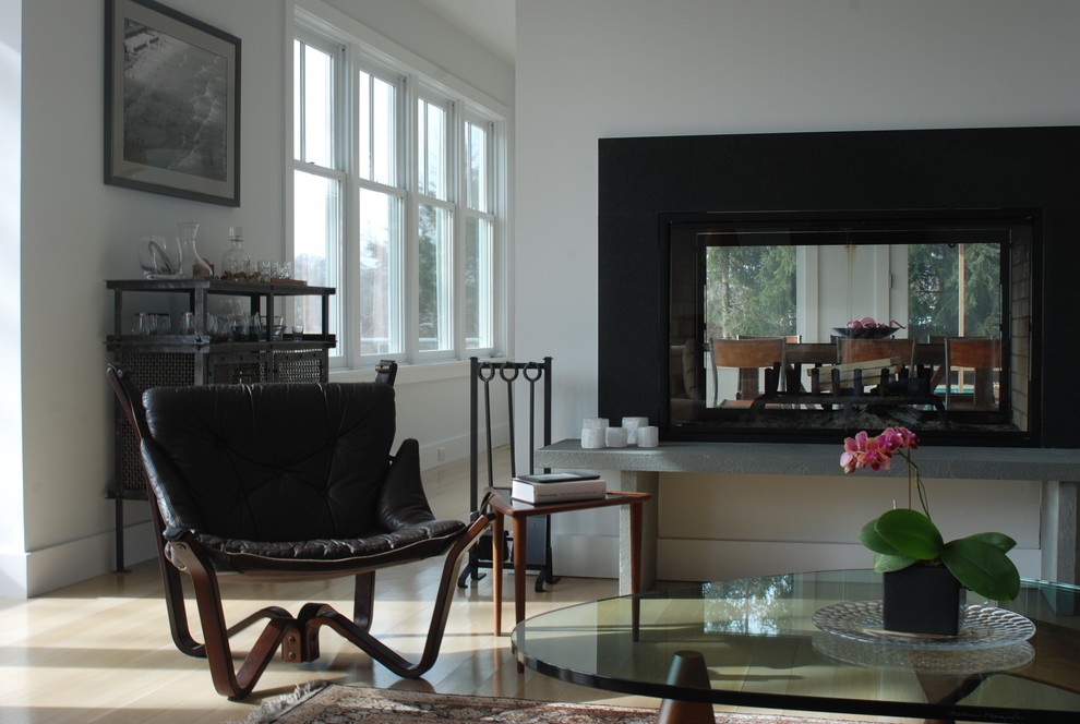 Inspiration for a contemporary living room in New York with a two-sided fireplace and white walls.
