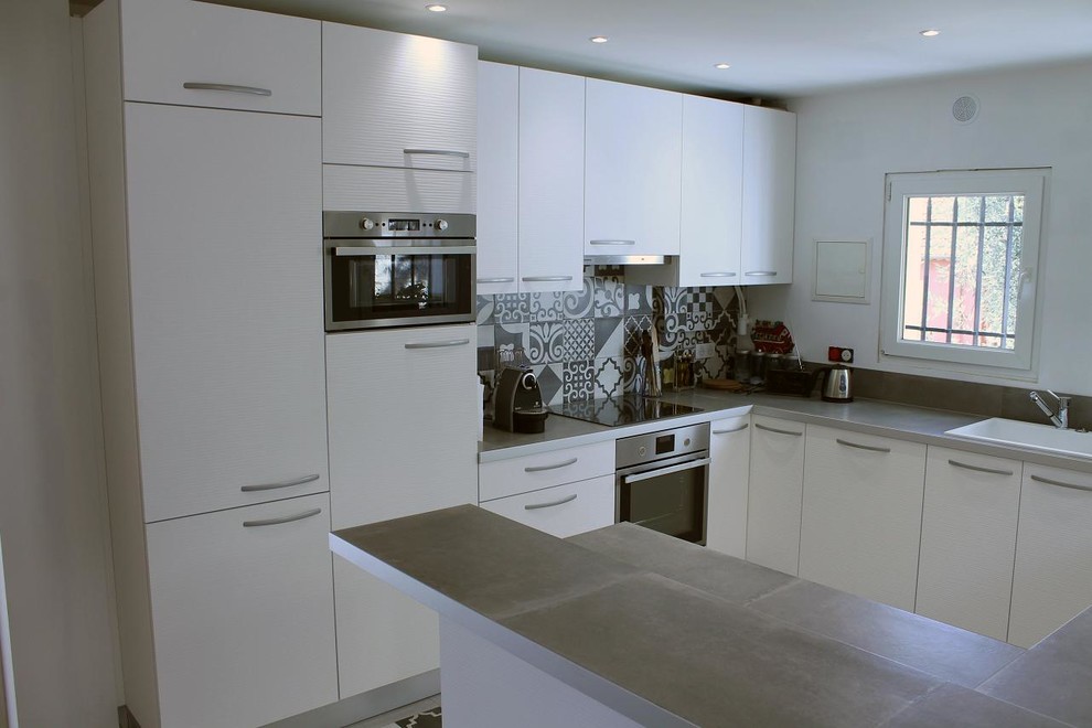 Photo of a large modern u-shaped separate kitchen in Nice with a drop-in sink, flat-panel cabinets, white cabinets, laminate benchtops, grey splashback, ceramic splashback, stainless steel appliances, ceramic floors and no island.