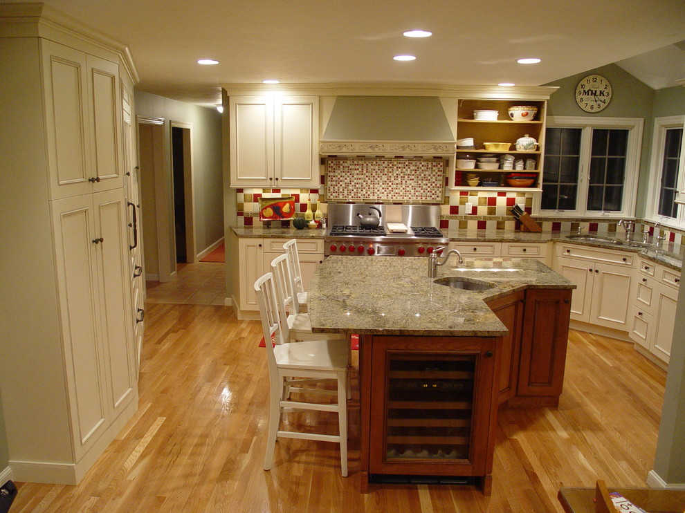 This is an example of a mid-sized traditional eat-in kitchen in Boston with an undermount sink, recessed-panel cabinets, white cabinets, granite benchtops, red splashback and with island.