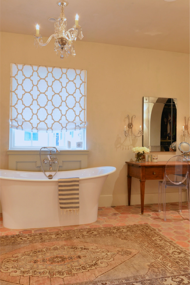 This is an example of a large mediterranean master bathroom in Other with a freestanding tub, multi-coloured tile, beige walls and terra-cotta floors.