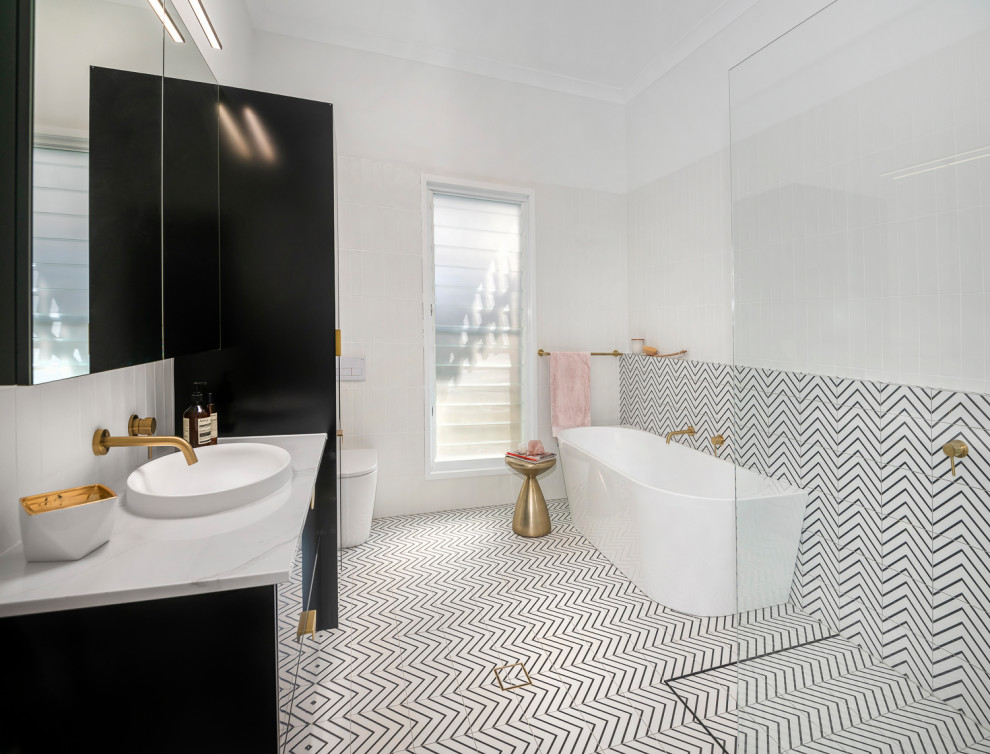 Design ideas for a large contemporary kids bathroom in Brisbane with black cabinets, a freestanding tub, an open shower, a wall-mount toilet, black and white tile, ceramic tile, white walls, ceramic floors, a vessel sink, marble benchtops, black floor, an open shower, white benchtops, a single vanity, a floating vanity and flat-panel cabinets.