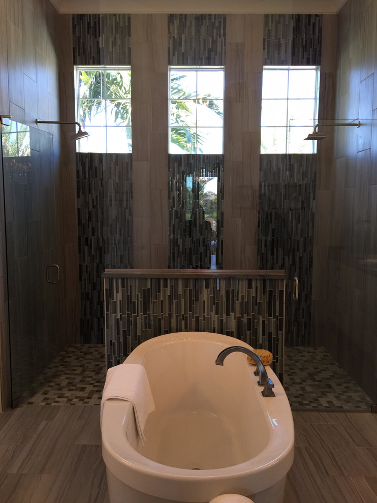Example of a large transitional master beige tile, brown tile, gray tile and porcelain tile light wood floor and beige floor freestanding bathtub design in Miami with beige walls, shaker cabinets, black cabinets, a one-piece toilet, an undermount sink and soapstone countertops