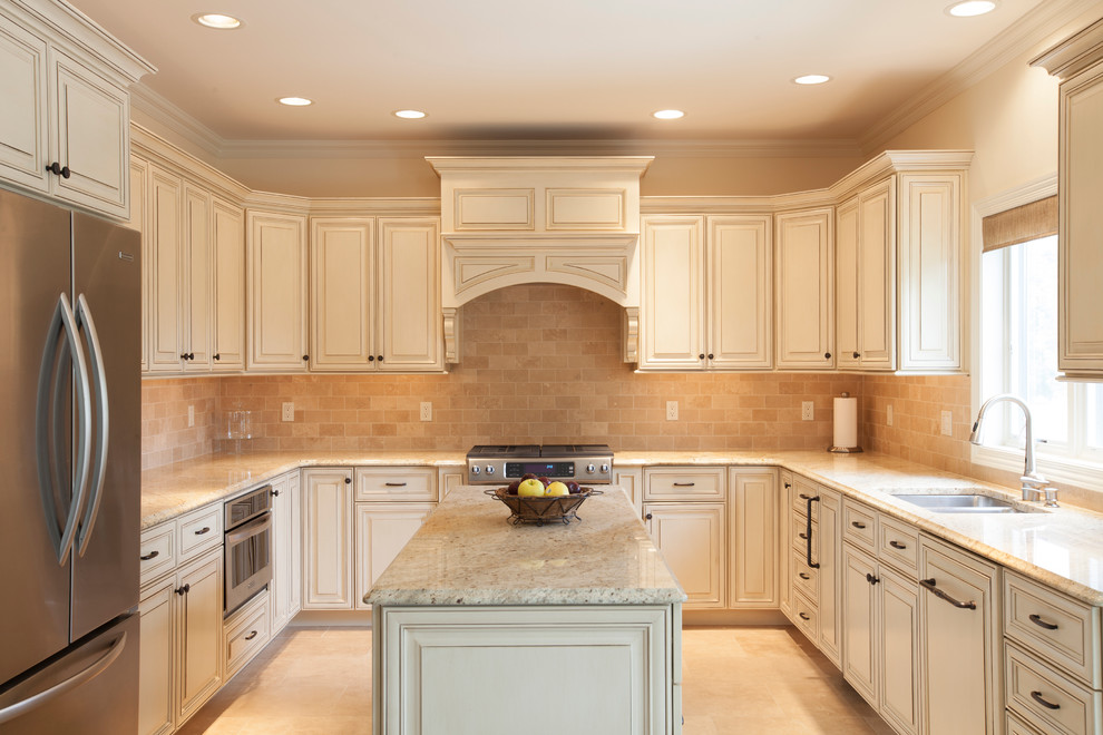 Photo of a mid-sized transitional u-shaped separate kitchen in Chicago with an undermount sink, white cabinets, granite benchtops, stainless steel appliances, with island, raised-panel cabinets, beige splashback, subway tile splashback, ceramic floors and beige floor.