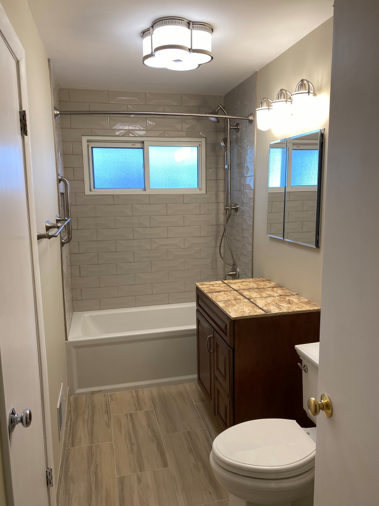 Photo of a medium sized midcentury ensuite bathroom in Chicago with raised-panel cabinets, dark wood cabinets, an alcove bath, a shower/bath combination, a two-piece toilet, grey tiles, grey walls, porcelain flooring, a submerged sink, engineered stone worktops, multi-coloured floors, a shower curtain, yellow worktops, a single sink, a freestanding vanity unit and metro tiles.