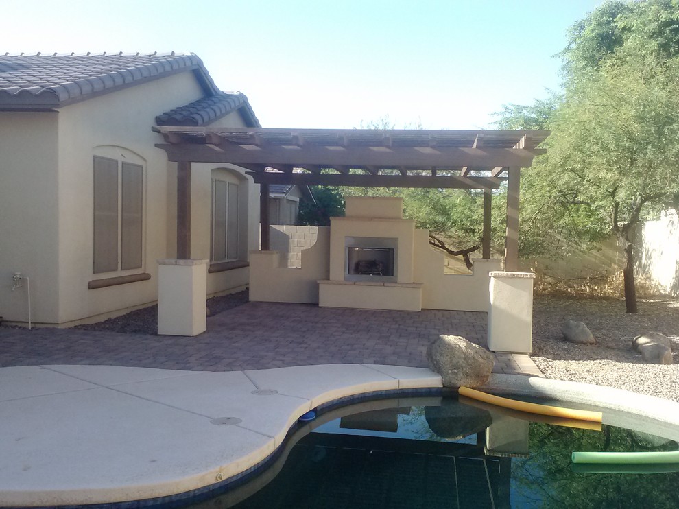 This is an example of a mid-sized mediterranean backyard patio in Phoenix with a fire feature, concrete pavers and a pergola.