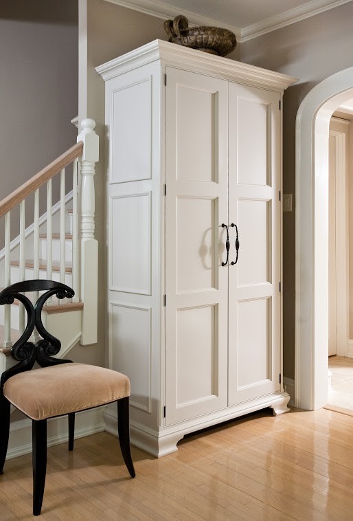 Inspiration for a mid-sized transitional gender-neutral light wood floor closet remodel with flat-panel cabinets and white cabinets