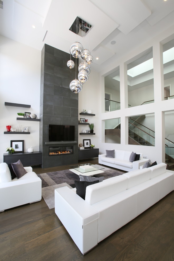 This is an example of a contemporary open concept living room in Toronto with white walls, dark hardwood floors, a ribbon fireplace and a wall-mounted tv.