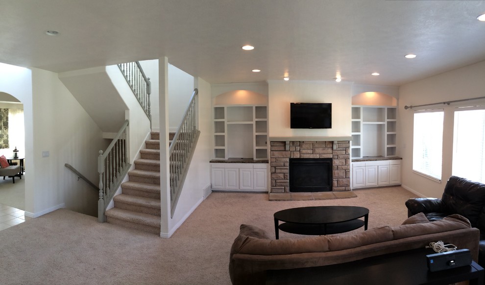 Photo of a mid-sized traditional living room in Austin with white walls, carpet, a standard fireplace, a stone fireplace surround, a wall-mounted tv and brown floor.