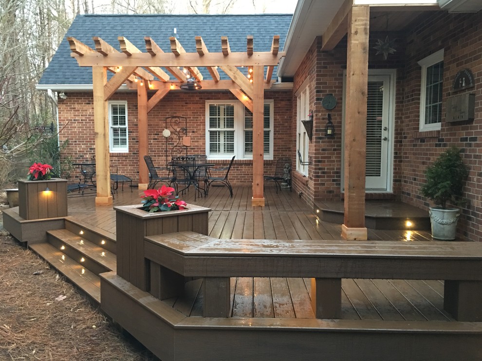 Deck - large traditional backyard deck idea with a pergola