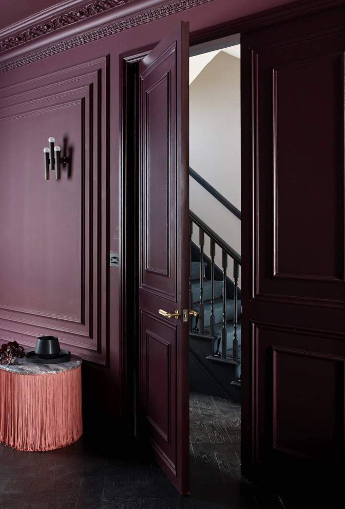 ロンドンにあるヴィクトリアン調のおしゃれな玄関 (赤い壁、濃色無垢フローリング、黒い床、パネル壁) の写真