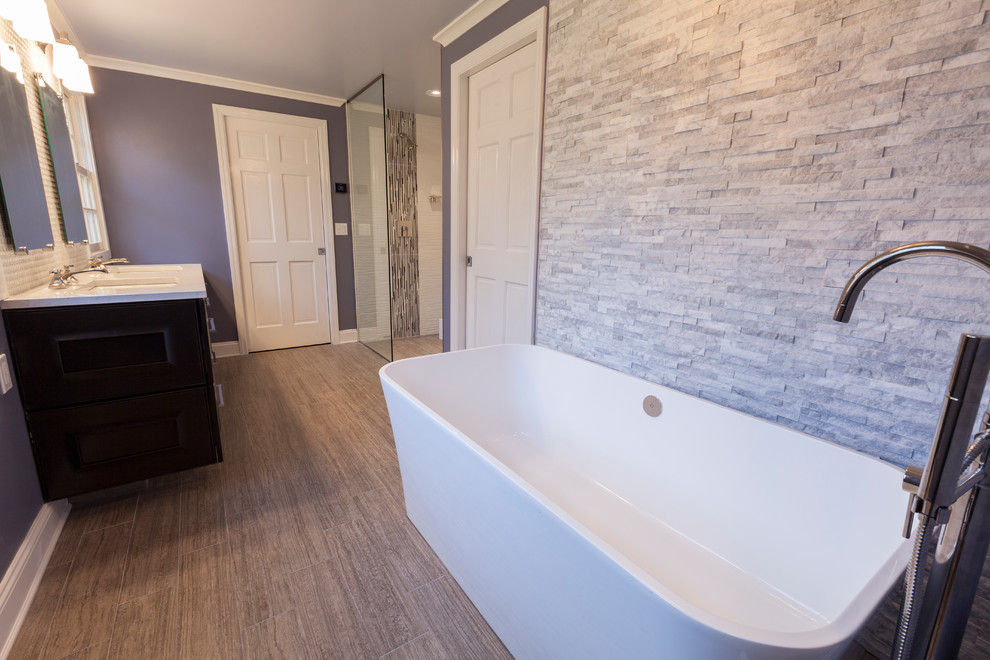This is an example of a large transitional master bathroom in Bridgeport with an undermount sink, recessed-panel cabinets, dark wood cabinets, engineered quartz benchtops, a freestanding tub, a curbless shower, a wall-mount toilet, white tile, porcelain tile, purple walls and porcelain floors.