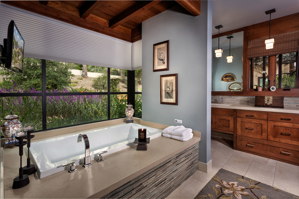 Photo of a transitional bathroom in Orange County with an undermount sink, shaker cabinets, dark wood cabinets, a drop-in tub, multi-coloured tile, matchstick tile and beige benchtops.
