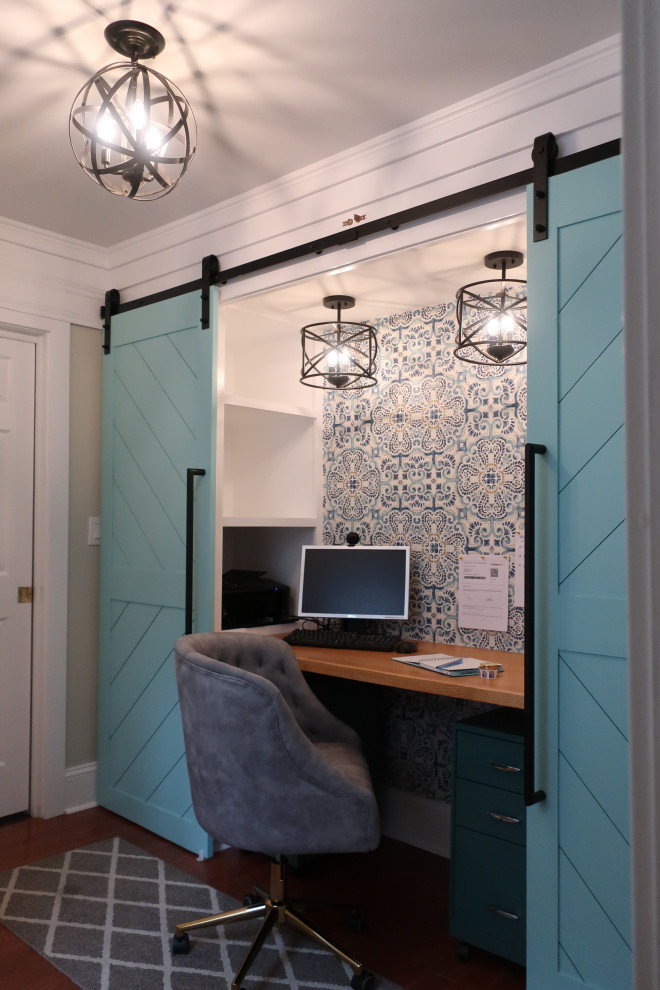 Imagen de despacho contemporáneo pequeño con paredes azules, escritorio empotrado, papel pintado y suelo marrón