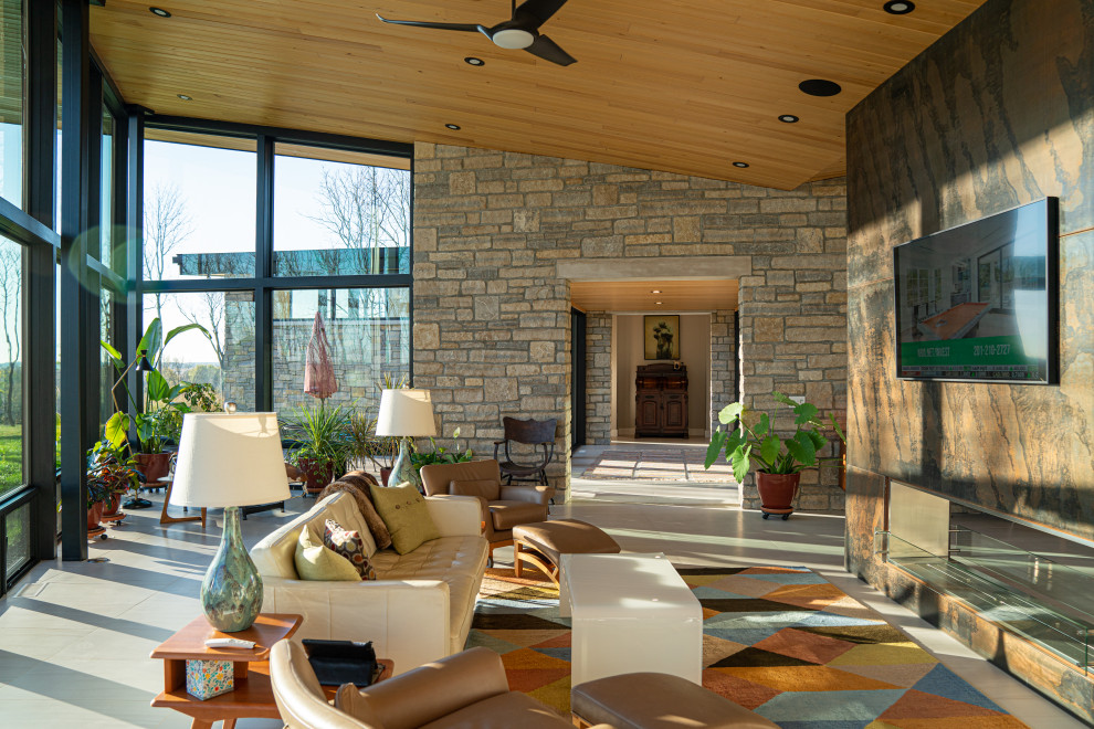 Стильный дизайн: открытая гостиная комната среднего размера в современном стиле с разноцветными стенами, полом из керамической плитки, горизонтальным камином, фасадом камина из металла, телевизором на стене, бежевым полом и деревянным потолком - последний тренд