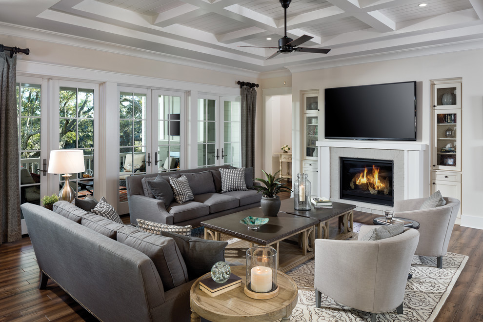 This is an example of a large traditional open concept living room in Tampa with white walls, medium hardwood floors, a standard fireplace, a brick fireplace surround and a wall-mounted tv.