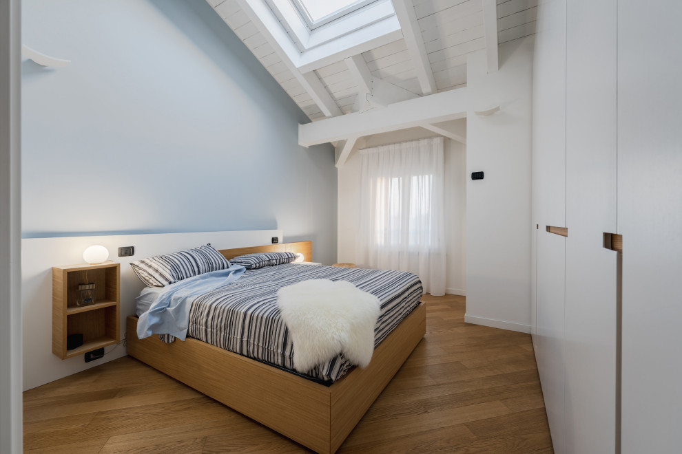 Photo of a large scandinavian master bedroom in Milan with multi-coloured walls, light hardwood flooring, beige floors and exposed beams.