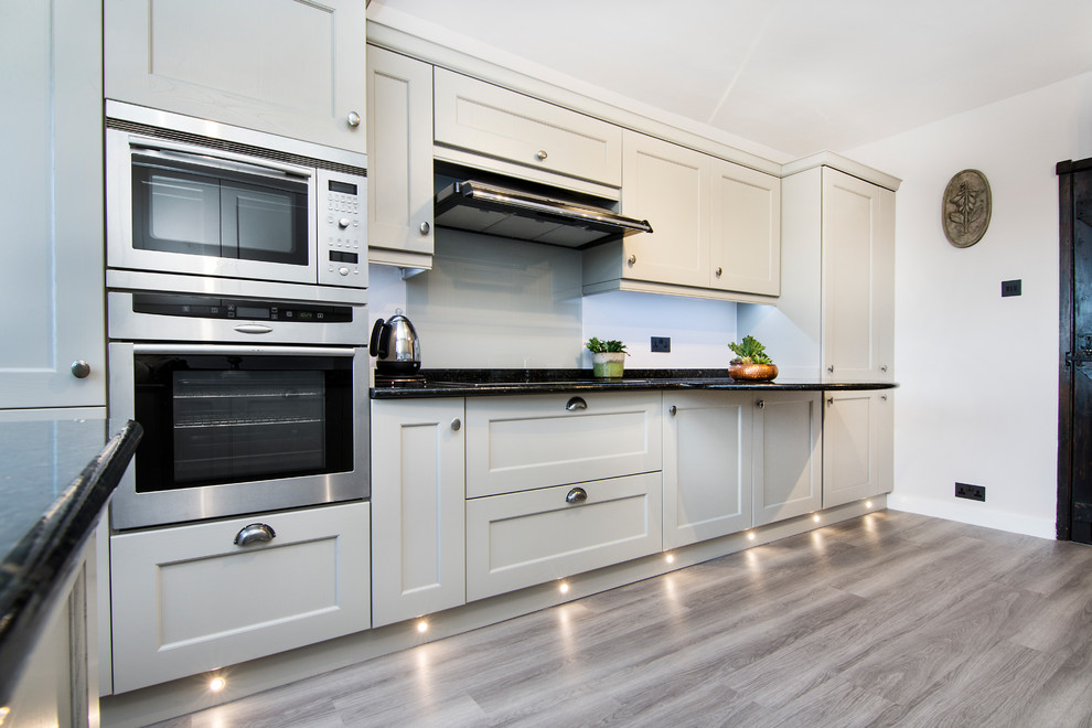 This is an example of a small traditional u-shaped separate kitchen in Essex with shaker cabinets, granite benchtops and multi-coloured benchtop.