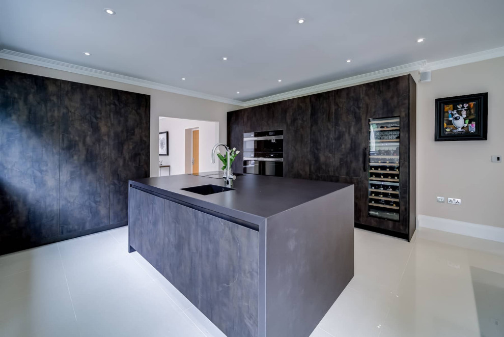 Photo of a large modern galley open plan kitchen in London with a built-in sink, flat-panel cabinets, dark wood cabinets, black appliances, porcelain flooring, multiple islands, white floors and black worktops.