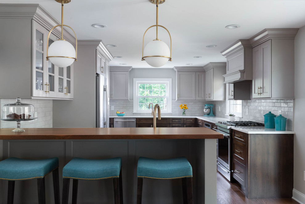 Example of a large transitional l-shaped medium tone wood floor and brown floor eat-in kitchen design with an undermount sink, recessed-panel cabinets, medium tone wood cabinets, quartz countertops, white backsplash, subway tile backsplash, stainless steel appliances, a peninsula and yellow countertops
