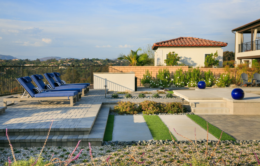 Inspiration for a large contemporary backyard full sun garden in San Diego with concrete pavers and a metal fence.