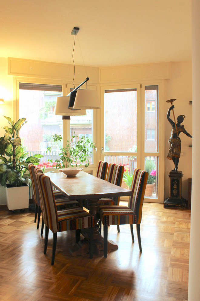 Design ideas for a traditional open plan dining in Milan with light hardwood floors.