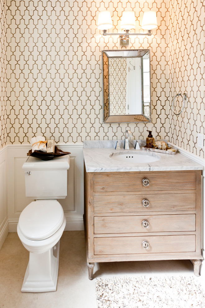 Photo of a beach style powder room in San Francisco with flat-panel cabinets, light wood cabinets, marble benchtops, an undermount sink, multi-coloured walls and a two-piece toilet.