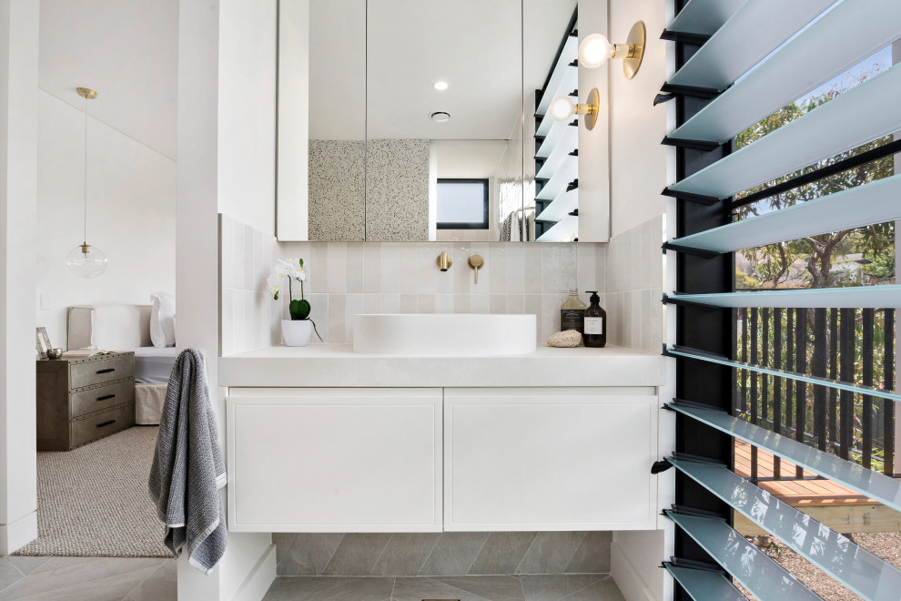 Inspiration for a beach style bathroom in Sydney with flat-panel cabinets, white cabinets, beige tile, gray tile, white tile, white walls, a vessel sink, grey floor, white benchtops, a single vanity and a floating vanity.