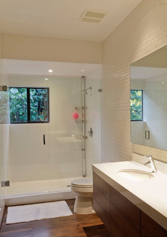 This is an example of a mid-sized modern kids bathroom in Miami with flat-panel cabinets, brown cabinets, white tile, ceramic tile, a drop-in sink, granite benchtops, a curbless shower, a hinged shower door, white walls, bamboo floors and brown floor.