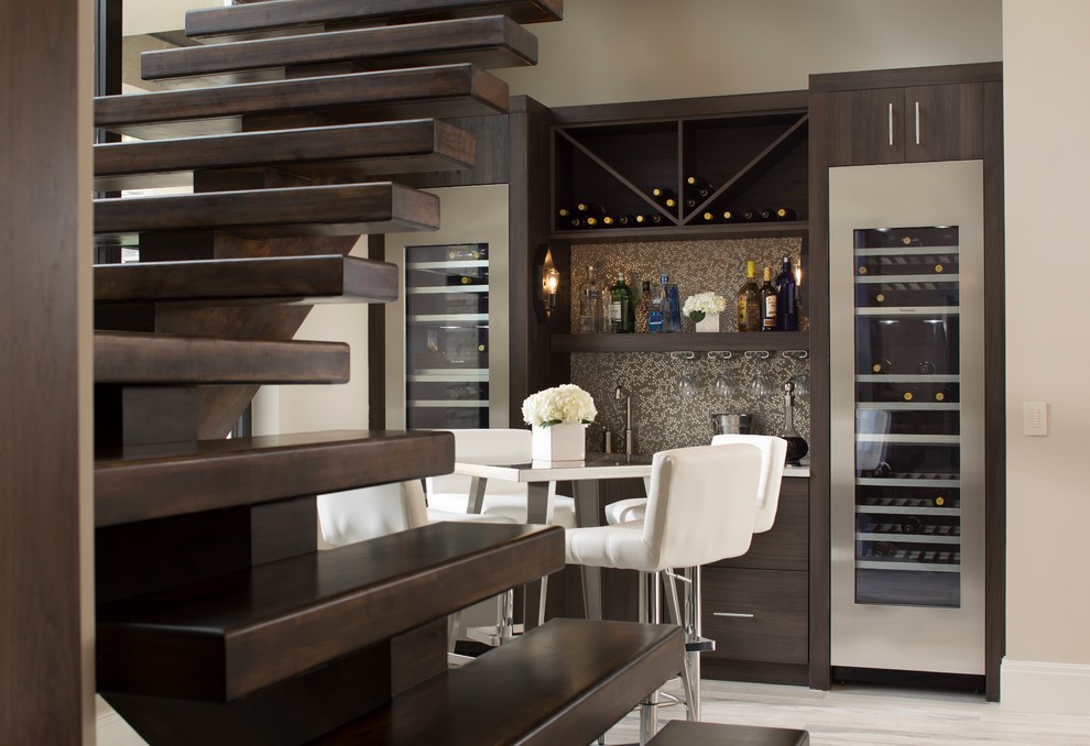 Mid-sized contemporary single-wall wet bar in Orlando with flat-panel cabinets, dark wood cabinets, quartz benchtops, multi-coloured splashback, light hardwood floors and grey floor.