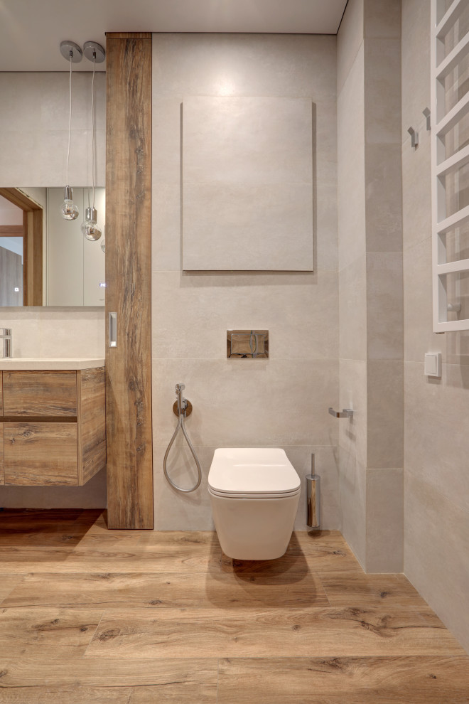 Photo of a mid-sized contemporary powder room in Saint Petersburg with flat-panel cabinets, light wood cabinets, a bidet, gray tile, limestone, grey walls, wood-look tile, an undermount sink, quartzite benchtops, beige floor, white benchtops and a floating vanity.
