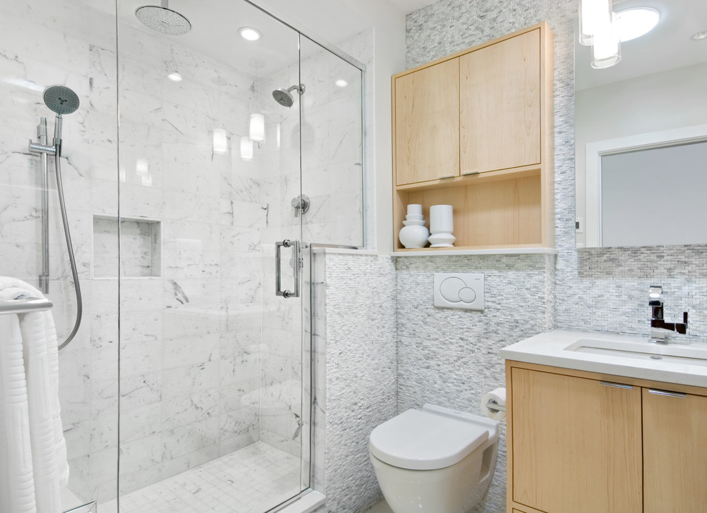 Inspiration for a small contemporary bathroom in Ottawa with an undermount sink, flat-panel cabinets, light wood cabinets, engineered quartz benchtops, a wall-mount toilet, white tile, stone tile, grey walls and porcelain floors.