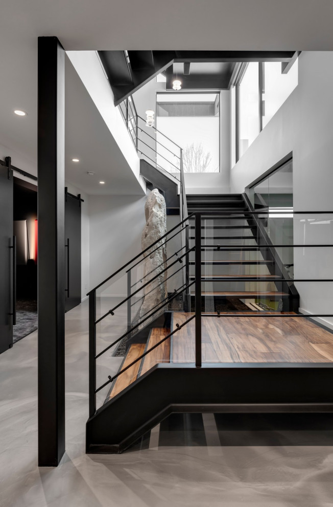 Geräumige Moderne Holztreppe in U-Form mit Holz-Setzstufen, Stahlgeländer und Wandgestaltungen in Calgary