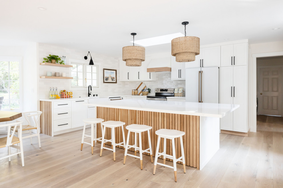 Large coastal open plan kitchen in San Francisco with shaker cabinets, white cabinets, engineered stone countertops and an island.