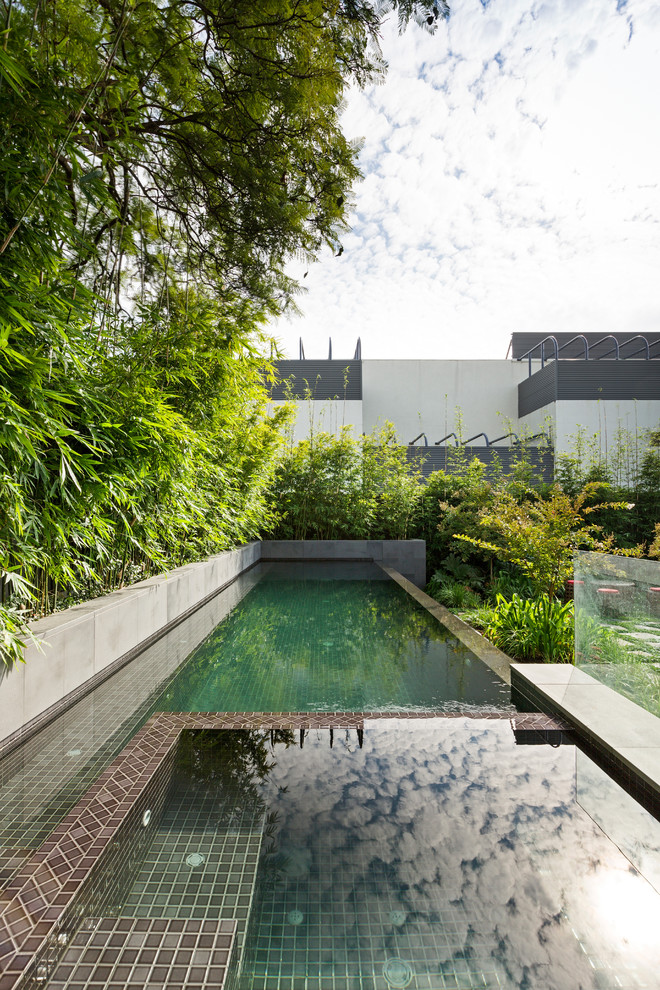 This is an example of a mid-sized asian backyard rectangular pool in Melbourne with tile.