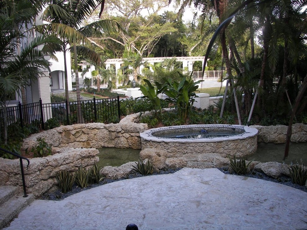 Pool fountain - transitional backyard stone and custom-shaped aboveground pool fountain idea in Miami