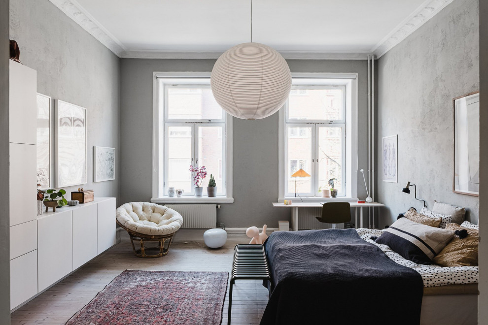 Immagine di una camera da letto scandinava con pareti grigie, parquet chiaro e pavimento beige