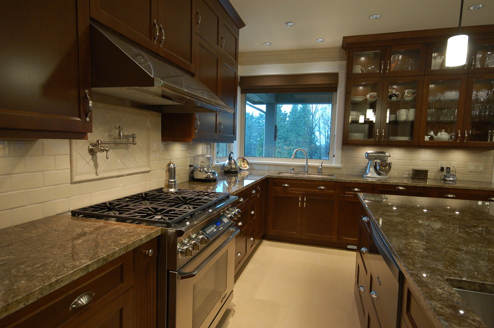 This is an example of a large traditional u-shaped eat-in kitchen in Vancouver with an undermount sink, flat-panel cabinets, dark wood cabinets, granite benchtops, beige splashback, ceramic splashback, stainless steel appliances, porcelain floors and with island.