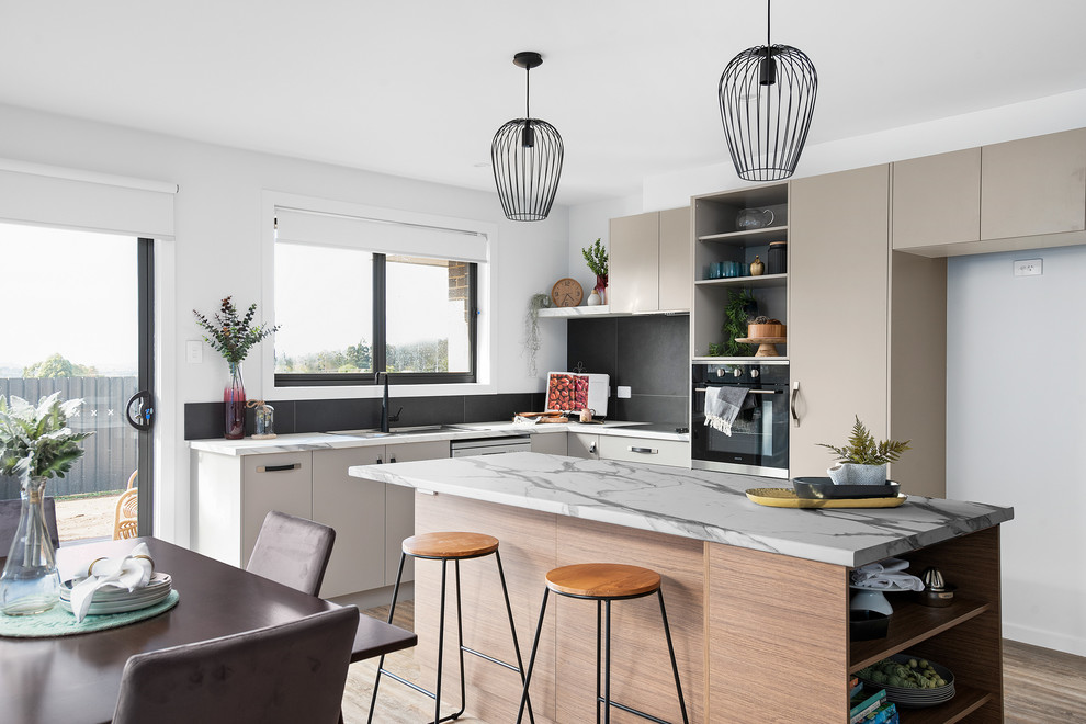 Inspiration for a mid-sized contemporary galley open plan kitchen in Other with a single-bowl sink, recessed-panel cabinets, grey cabinets, laminate benchtops, black splashback, ceramic splashback, stainless steel appliances, vinyl floors, with island, brown floor and multi-coloured benchtop.