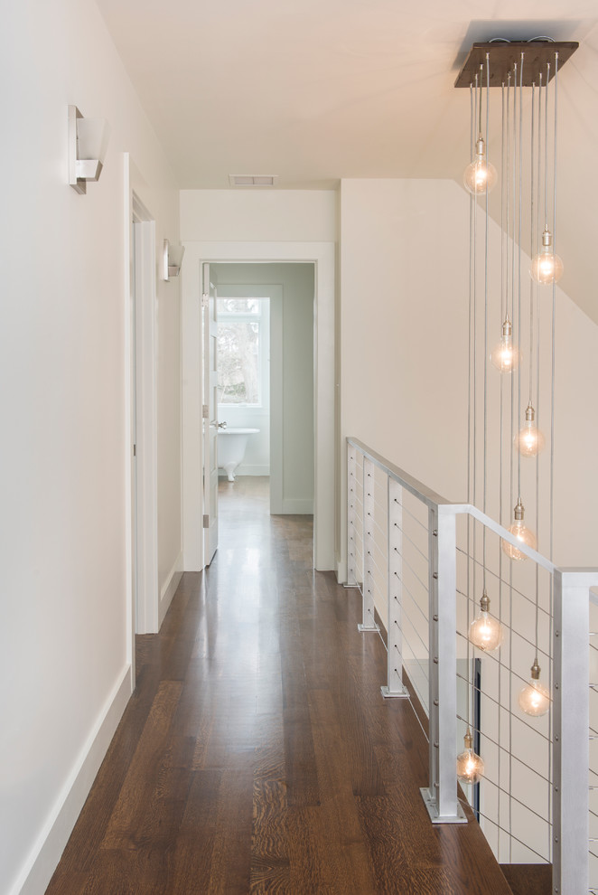 This is an example of a contemporary hallway in Boston with white walls and dark hardwood floors.
