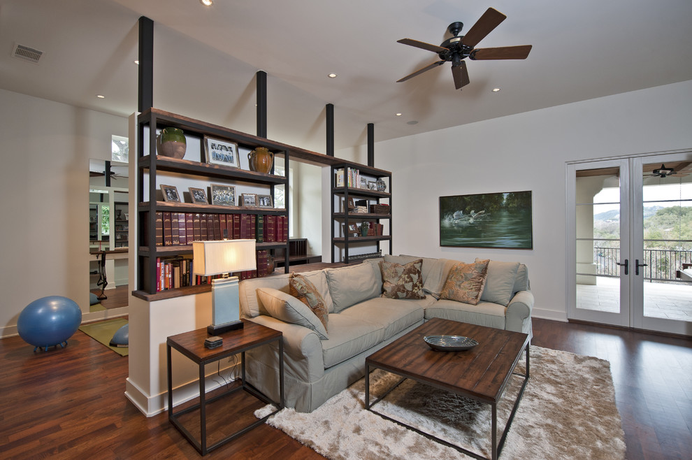 This is an example of a contemporary open concept family room in Austin with white walls and dark hardwood floors.