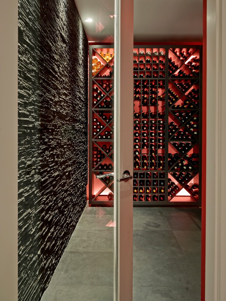 This is an example of a small contemporary wine cellar in London with slate floors, diamond bins and grey floor.
