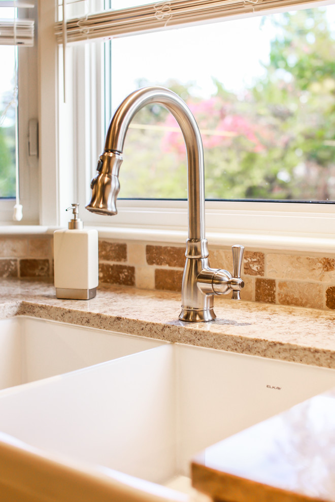 Example of a mid-sized transitional u-shaped porcelain tile home design design in Toronto with a farmhouse sink, shaker cabinets, dark wood cabinets, quartz countertops, beige backsplash, stone tile backsplash, stainless steel appliances and no island