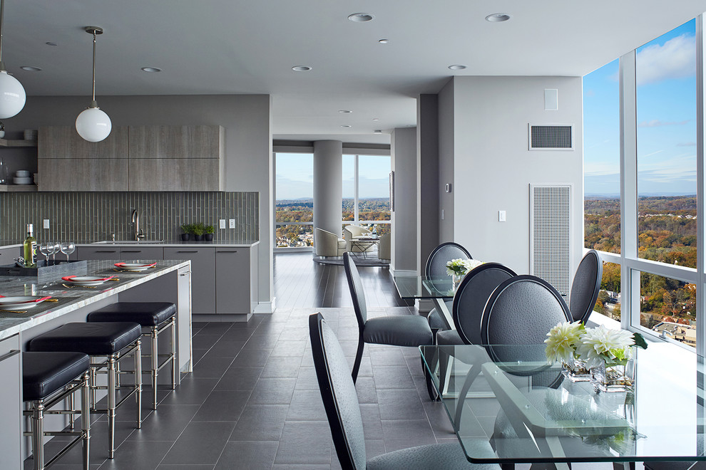 Design ideas for an expansive contemporary u-shaped eat-in kitchen in New York with an undermount sink, flat-panel cabinets, grey cabinets, quartz benchtops, grey splashback, glass tile splashback, stainless steel appliances, porcelain floors, with island, grey floor and multi-coloured benchtop.
