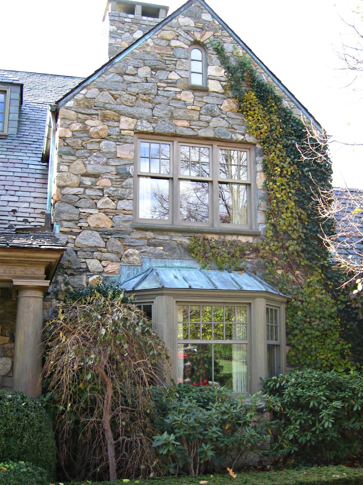 Expansive country three-storey exterior in New York with stone veneer.