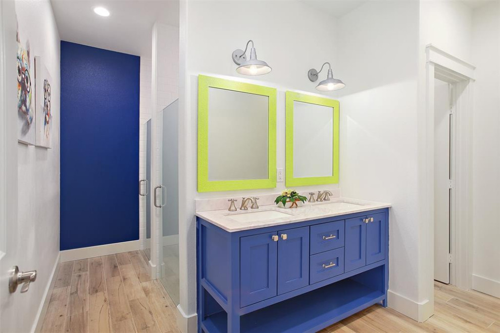 Expansive modern family bathroom with shaker cabinets, blue cabinets, a double shower, wood-effect flooring, a submerged sink, engineered stone worktops, a hinged door, white worktops, an enclosed toilet, double sinks and a built in vanity unit.