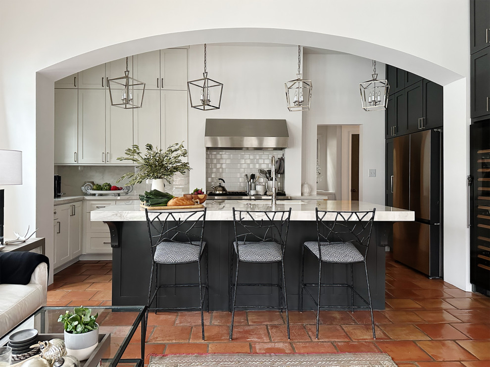 Foto de cocina mediterránea de tamaño medio con electrodomésticos de acero inoxidable y una isla