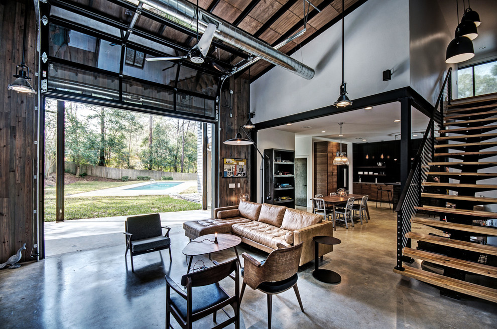 Living room - industrial open concept concrete floor and gray floor living room idea in Jackson with white walls